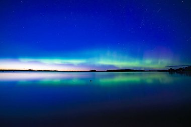 İsveç 'teki sakin göl üzerindeki kuzey ışıklarının manzarası (Aurora borealis) Farnebofjarden Milli Parkı