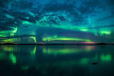 İsveç 'teki sakin göl üzerindeki kuzey ışıklarının manzarası (Aurora borealis) Farnebofjarden Milli Parkı