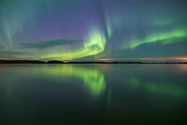 İsveç 'teki sakin göl üzerindeki kuzey ışıklarının manzarası (Aurora borealis) Farnebofjarden Milli Parkı