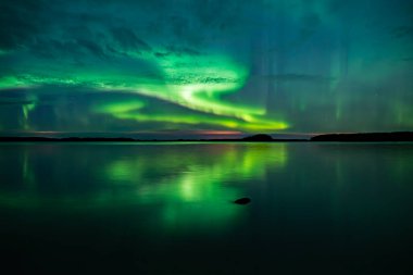 İsveç 'teki sakin göl üzerindeki kuzey ışıklarının manzarası (Aurora borealis) Farnebofjarden Milli Parkı