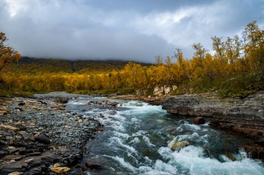 İsveç 'in kuzeyindeki Abisko Ulusal Parkı' nda güzel bir nehir manzarasında gün doğumu sabahı.