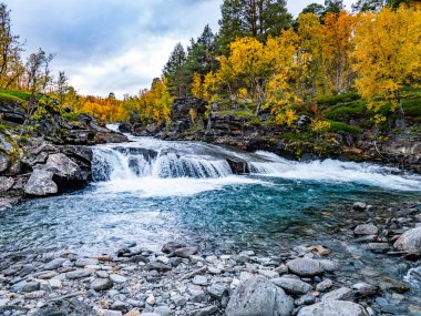 İsveç 'in kuzeyindeki Abisko Ulusal Parkı' nda güzel bir nehir manzarasında gün doğumu sabahı.