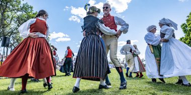 Torstuna, İsveç - 21 Haziran - 21 Haziran 2024 'te İsveç' in Torstuna kentinde düzenlenen yaz ortası festivalinde geleneksel folklor kıyafeti içinde