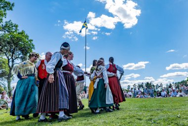 Torstuna, İsveç - 21 Haziran - 21 Haziran 2024 'te İsveç' in Torstuna kentinde düzenlenen yaz ortası festivalinde geleneksel folklor kıyafeti içinde