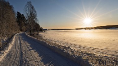 Kır manzarası soğuk bir kış manzarası. Güneş doğarken kar ve donla kaplı.
