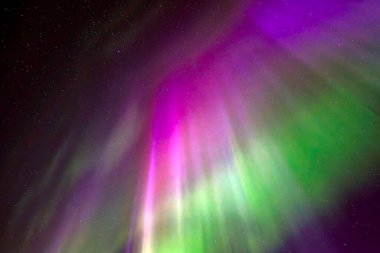 Kuzey ışıklarının bulutlu gökyüzünde dans edişinin manzarası