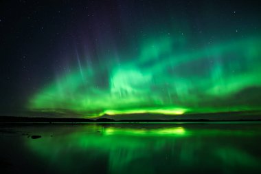 İsveç 'teki sakin göl üzerindeki kuzey ışıklarının manzarası (Aurora borealis) Farnebofjarden Milli Parkı