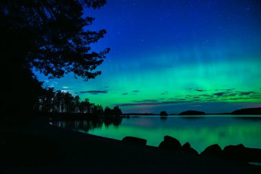 İsveç 'teki sakin göl üzerindeki kuzey ışıklarının manzarası (Aurora borealis) Farnebofjarden Milli Parkı