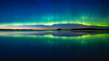 İsveç 'teki sakin göl üzerindeki kuzey ışıklarının manzarası (Aurora borealis) Farnebofjarden Milli Parkı