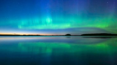 İsveç 'teki sakin göl üzerindeki kuzey ışıklarının manzarası (Aurora borealis) Farnebofjarden Milli Parkı