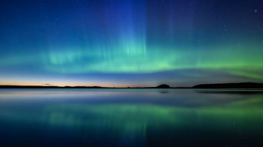 İsveç 'teki sakin göl üzerindeki kuzey ışıklarının manzarası (Aurora borealis) Farnebofjarden Milli Parkı