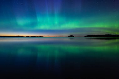 İsveç 'teki sakin göl üzerindeki kuzey ışıklarının manzarası (Aurora borealis) Farnebofjarden Milli Parkı