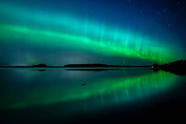 İsveç 'teki sakin göl üzerindeki kuzey ışıklarının manzarası (Aurora borealis) Farnebofjarden Milli Parkı