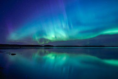 İsveç 'teki sakin göl üzerindeki kuzey ışıklarının manzarası (Aurora borealis) Farnebofjarden Milli Parkı