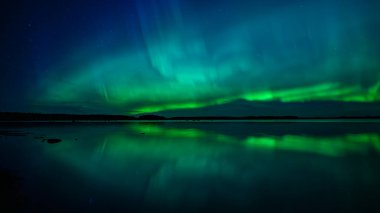 İsveç 'teki sakin göl üzerindeki kuzey ışıklarının manzarası (Aurora borealis) Farnebofjarden Milli Parkı