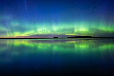İsveç 'teki sakin göl üzerindeki kuzey ışıklarının manzarası (Aurora borealis) Farnebofjarden Milli Parkı