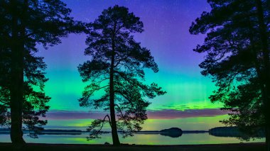 İsveç 'teki sakin göl üzerindeki kuzey ışıklarının manzarası (Aurora borealis) Farnebofjarden Milli Parkı