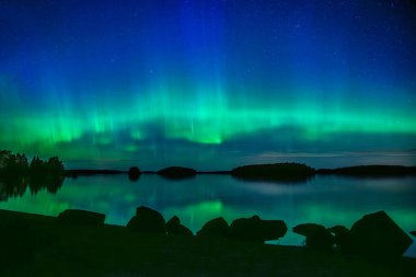 İsveç 'teki sakin göl üzerindeki kuzey ışıklarının manzarası (Aurora borealis) Farnebofjarden Milli Parkı