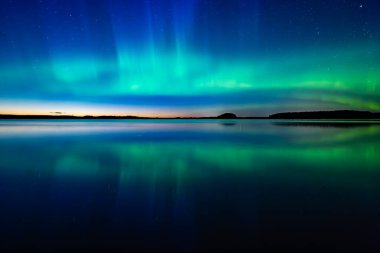 İsveç 'teki sakin göl üzerindeki kuzey ışıklarının manzarası (Aurora borealis) Farnebofjarden Milli Parkı