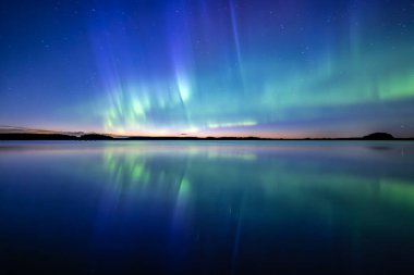 İsveç 'teki sakin göl üzerindeki kuzey ışıklarının manzarası (Aurora borealis) Farnebofjarden Milli Parkı