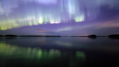 İsveç 'teki sakin göl üzerindeki kuzey ışıklarının manzarası (Aurora borealis) Farnebofjarden Milli Parkı