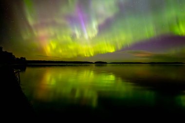 İsveç 'teki sakin göl üzerindeki kuzey ışıklarının manzarası (Aurora borealis) Farnebofjarden Milli Parkı