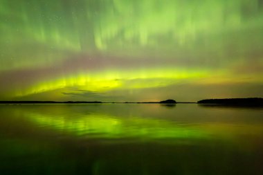 İsveç 'teki sakin göl üzerindeki kuzey ışıklarının manzarası (Aurora borealis) Farnebofjarden Milli Parkı