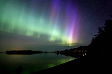 İsveç 'teki sakin göl üzerindeki kuzey ışıklarının manzarası (Aurora borealis) Farnebofjarden Milli Parkı