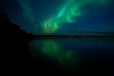 İsveç 'teki sakin göl üzerindeki kuzey ışıklarının manzarası (Aurora borealis) Farnebofjarden Milli Parkı