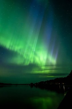 İsveç 'teki sakin göl üzerindeki kuzey ışıklarının manzarası (Aurora borealis) Farnebofjarden Milli Parkı
