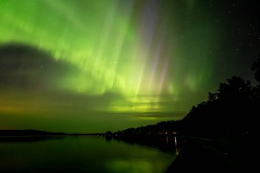 İsveç 'teki sakin göl üzerindeki kuzey ışıklarının manzarası (Aurora borealis) Farnebofjarden Milli Parkı
