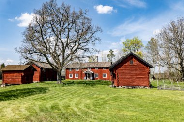 Baharda güzel bir çiftlik arazisinde tipik kırmızı bir kulübe..