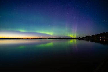 İsveç 'teki sakin göl üzerindeki kuzey ışıklarının manzarası (Aurora borealis) Farnebofjarden Milli Parkı