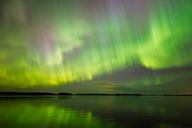 İsveç 'teki sakin göl üzerindeki kuzey ışıklarının manzarası (Aurora borealis) Farnebofjarden Milli Parkı