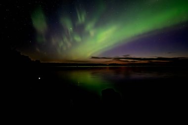 İsveç 'teki sakin göl üzerindeki kuzey ışıklarının manzarası (Aurora borealis) Farnebofjarden Milli Parkı