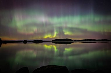 İsveç 'teki sakin göl üzerindeki kuzey ışıklarının manzarası (Aurora borealis) Farnebofjarden Milli Parkı