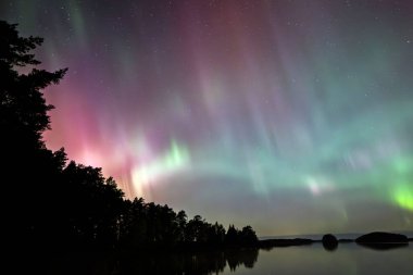 İsveç 'teki sakin göl üzerindeki kuzey ışıklarının manzarası (Aurora borealis) Farnebofjarden Milli Parkı
