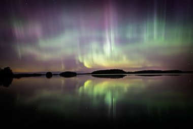İsveç 'teki sakin göl üzerindeki kuzey ışıklarının manzarası (Aurora borealis) Farnebofjarden Milli Parkı