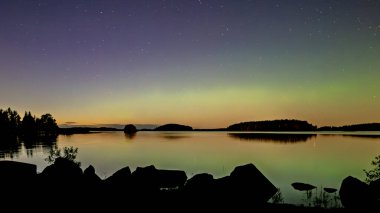 İsveç 'teki sakin göl üzerindeki kuzey ışıklarının manzarası (Aurora borealis) Farnebofjarden Milli Parkı