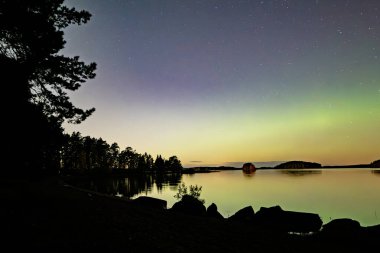 İsveç 'teki sakin göl üzerindeki kuzey ışıklarının manzarası (Aurora borealis) Farnebofjarden Milli Parkı