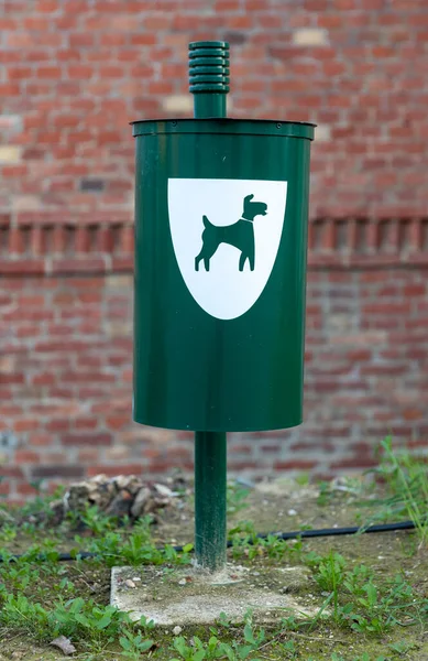 Green dog waste bin with plastic outdoor in park