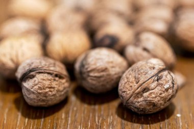 Ahşap masada soyulmamış ceviz yığını