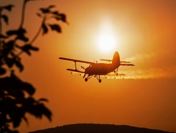 Silhouette Eines Klassischen Landwirtschaftlichen Doppeldeckers Fliegt Bei Sonnenuntergang Und Versprüht — Stockfoto