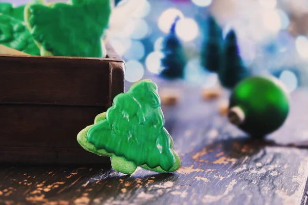 霜降りクリスマスツリーは 素朴なテーブルの上に緑色のアイシングでクッキーやビスケットを形成します 前景と背景がぼやけた選択的焦点 — ストック写真