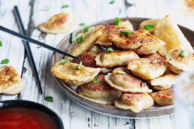 Altın kaplama Çin hamur köftesi, aynı zamanda Pot Stickers olarak da bilinir, tatlı ve ekşi soslu. Önplanı ve arkaplanı bulanık seçili odak.