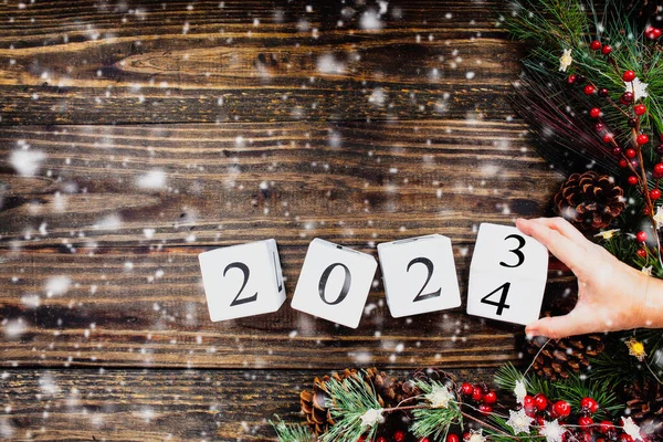 Kvinnans Hand Vänder Nyår 2021 Trä Kalenderblock Till 2023 Julgransljus Royaltyfria Stockfoton