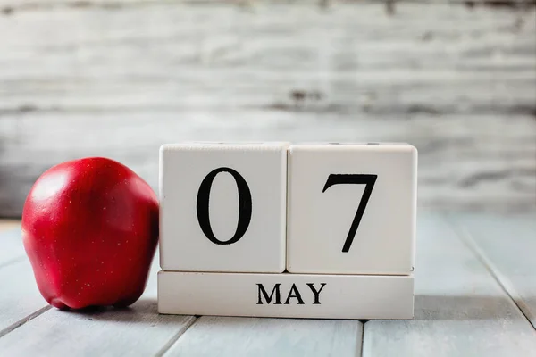 Vita Trä Kalenderblock Med Datum Maj Och Ett Rött Äpple Stockbild