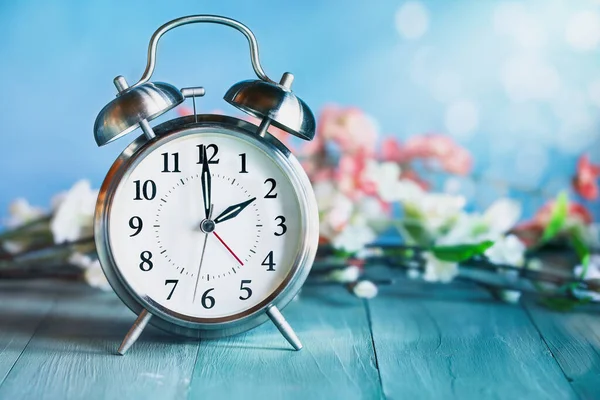 소박한 테이블 위에이 시계와 꽃으로 앞으로 시계를 설정합니다 배경을 선택적인 스톡 사진