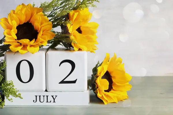 障害者のための特別レクリエーション ホワイトウッドのカレンダーブロックは 7月2日と美しい日光の花束とボケ バックグラウンドで選択的なフォーカス ロイヤリティフリーのストック画像