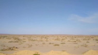 Arabanın penceresinin dışındaki çöl manzarası.